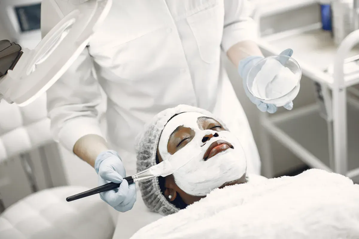 Woman relaxes during acne corrective facial treatment.