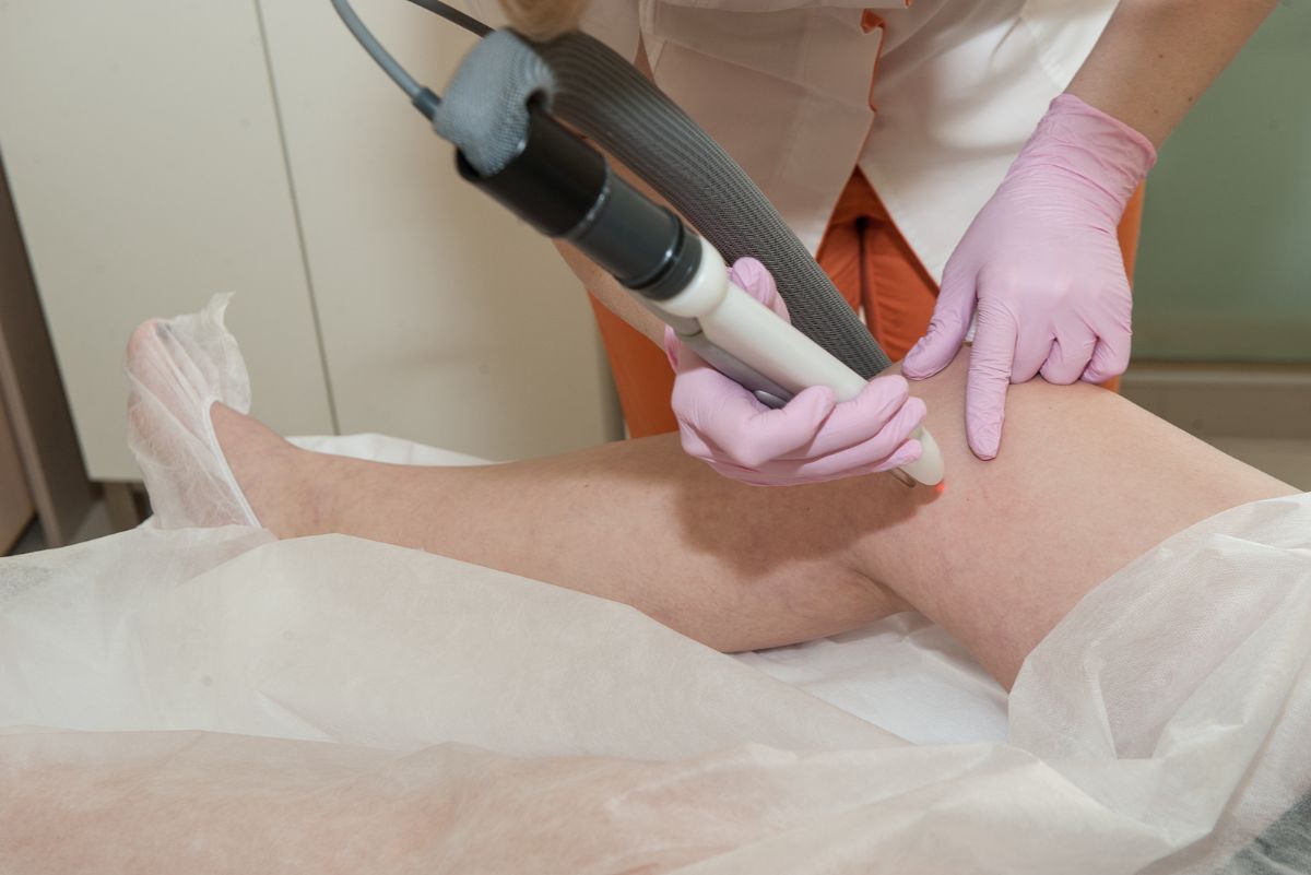 A technician at Namaste Skincare & Wellness in Henderson performs a laser vein removal treatment on a client’s legs using advanced handheld equipment.