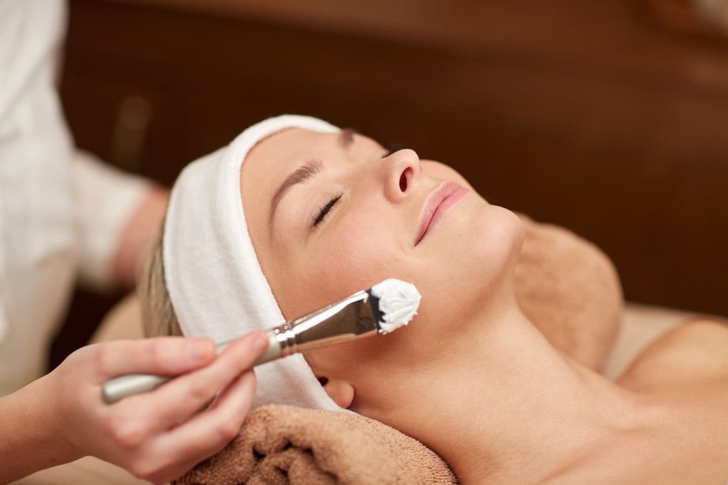Woman getting a facial in a spa setting.