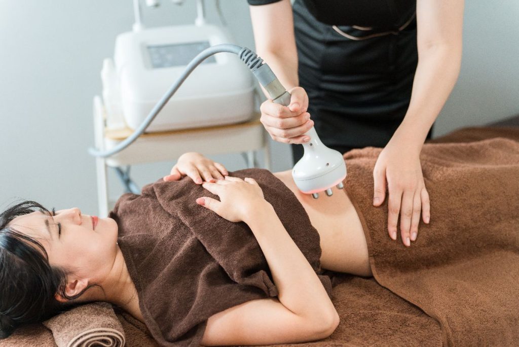 Technician uses belly fat reduction wand on female patient.