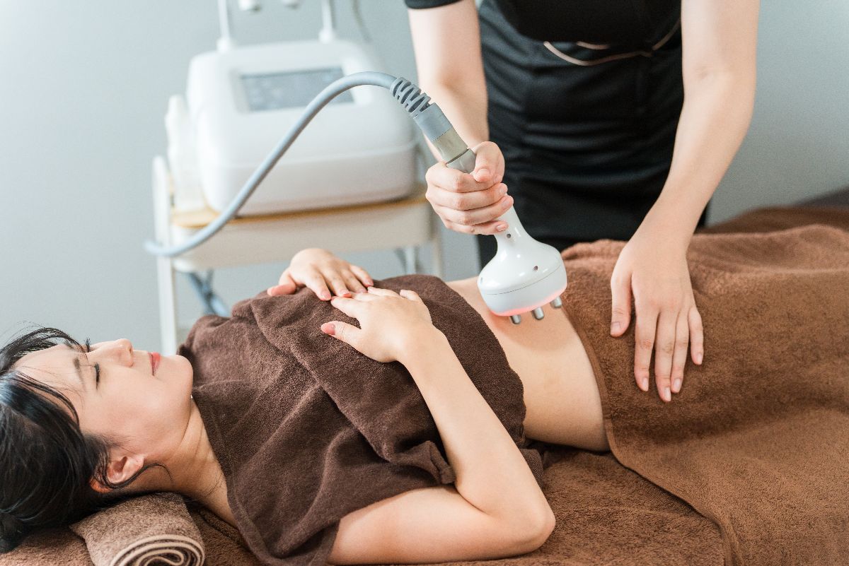 Technician uses belly fat reduction wand on female patient.